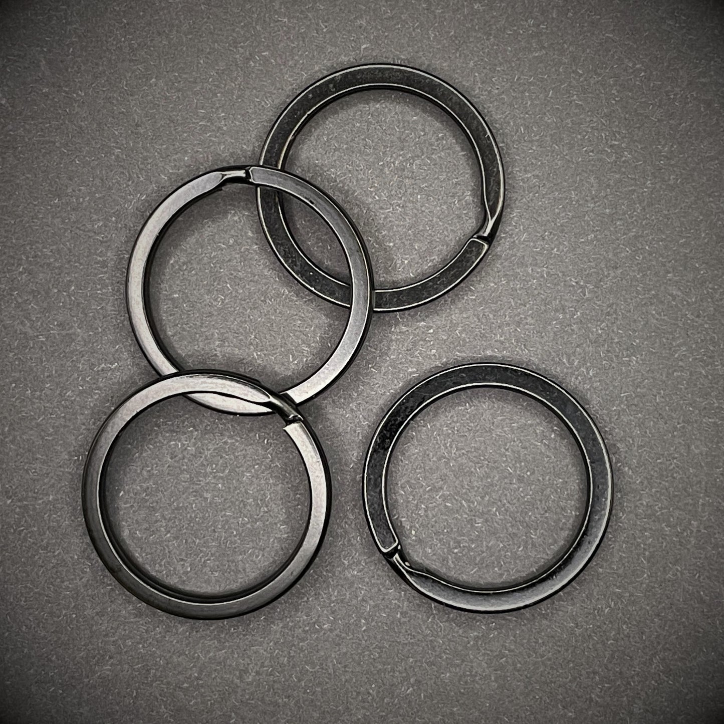 a group of black split rings arranged on a dark grey background