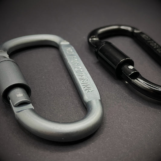 Black and grey carabiner marked 'NOT FOR CLIMBING' on a dark grey background.
