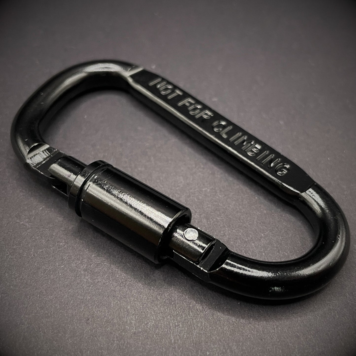 Black carabiner marked 'NOT FOR CLIMBING' on a dark grey background.