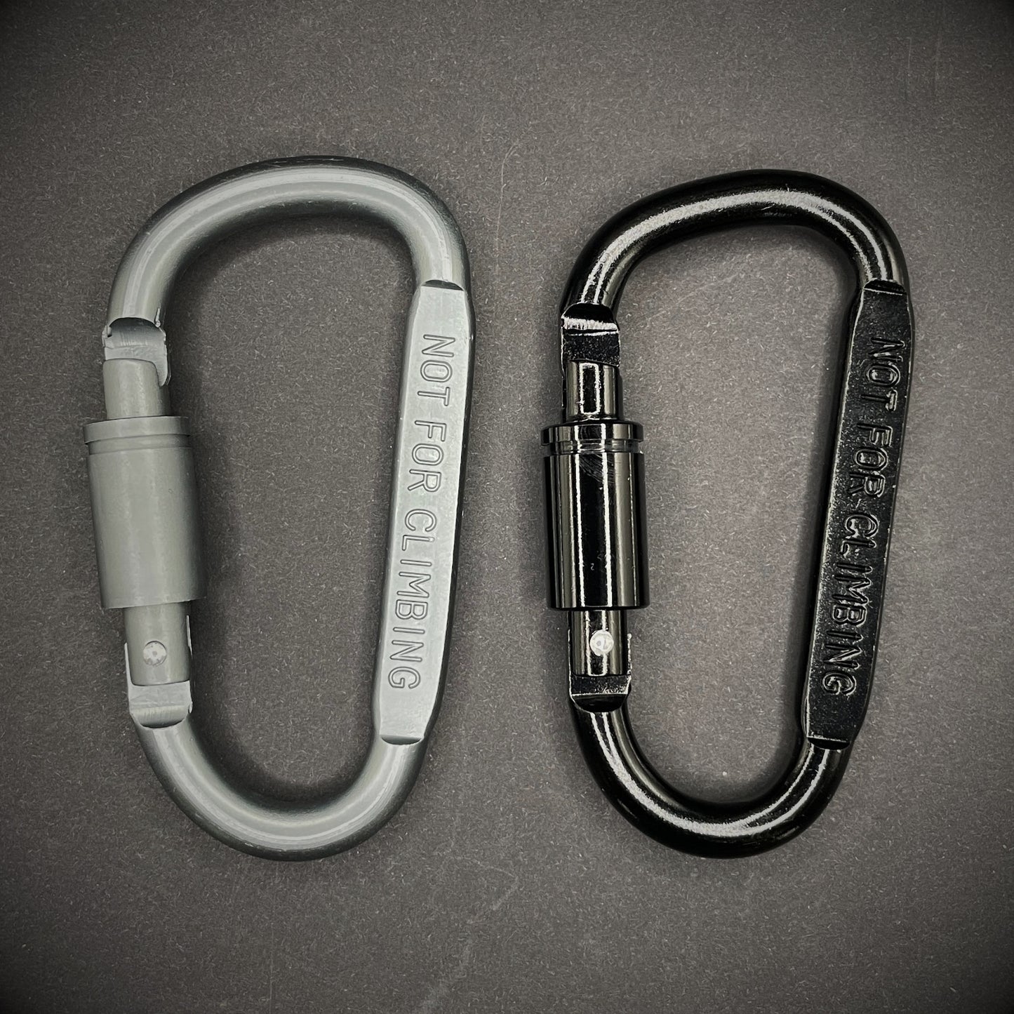 Black and grey carabiner marked 'NOT FOR CLIMBING' on a dark grey background.
