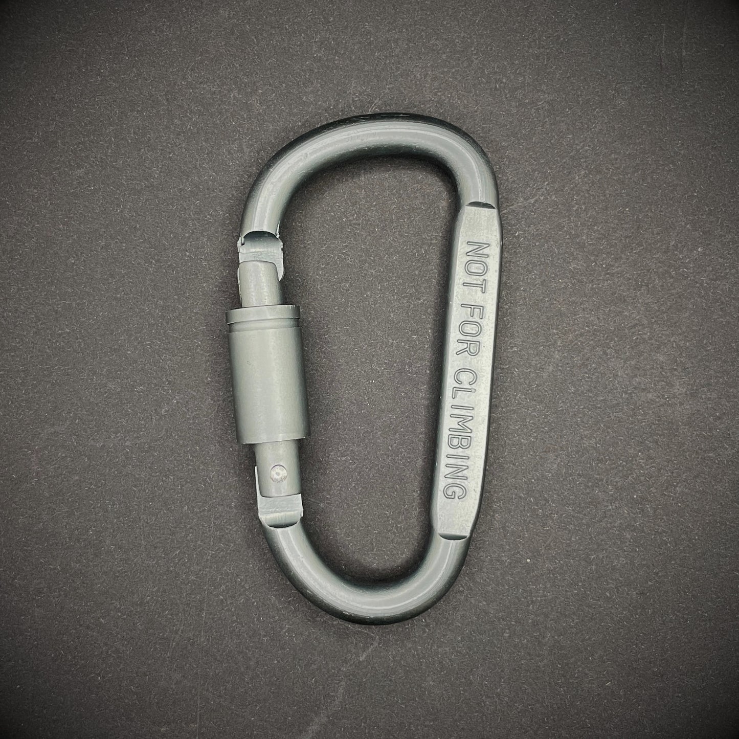 Grey carabiner marked 'NOT FOR CLIMBING' on a dark grey background.