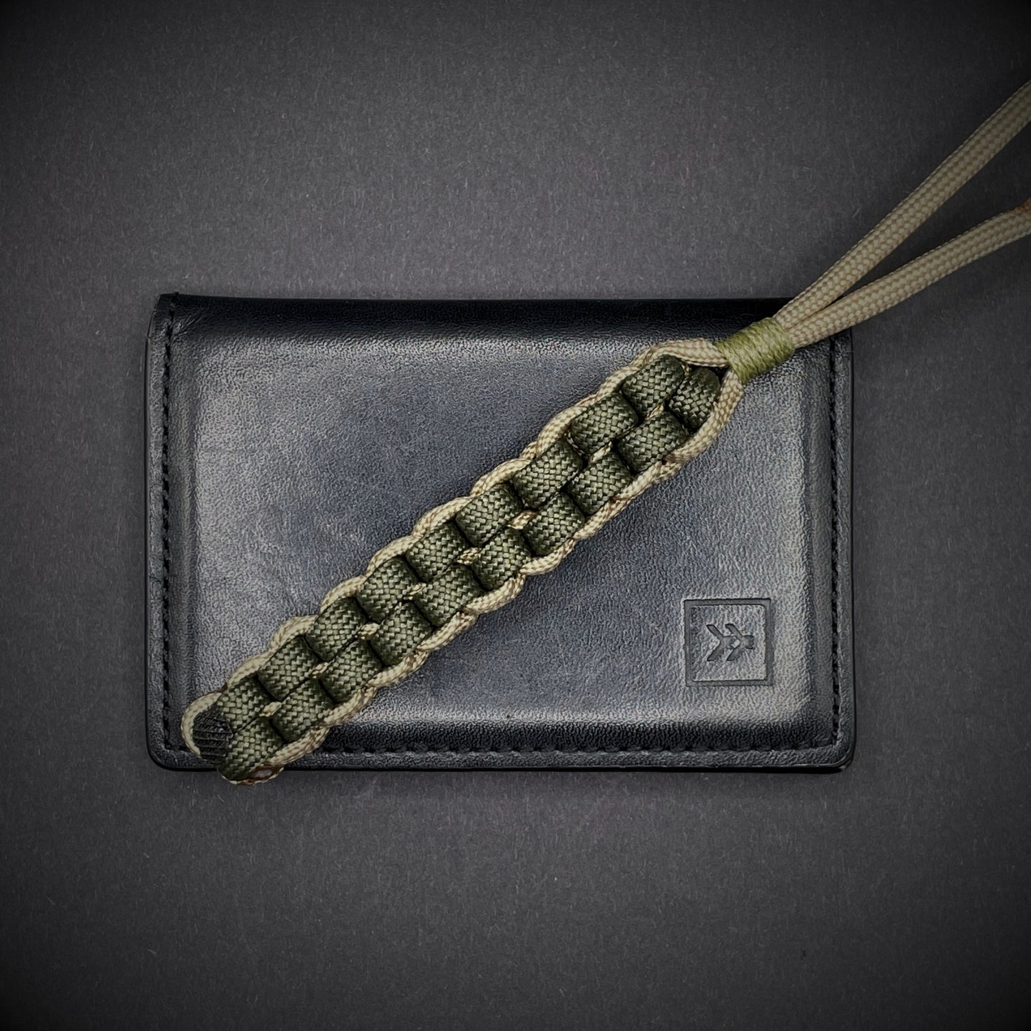 Flat lay of a 3 550 Paracord knife lanyards on a dark grey background