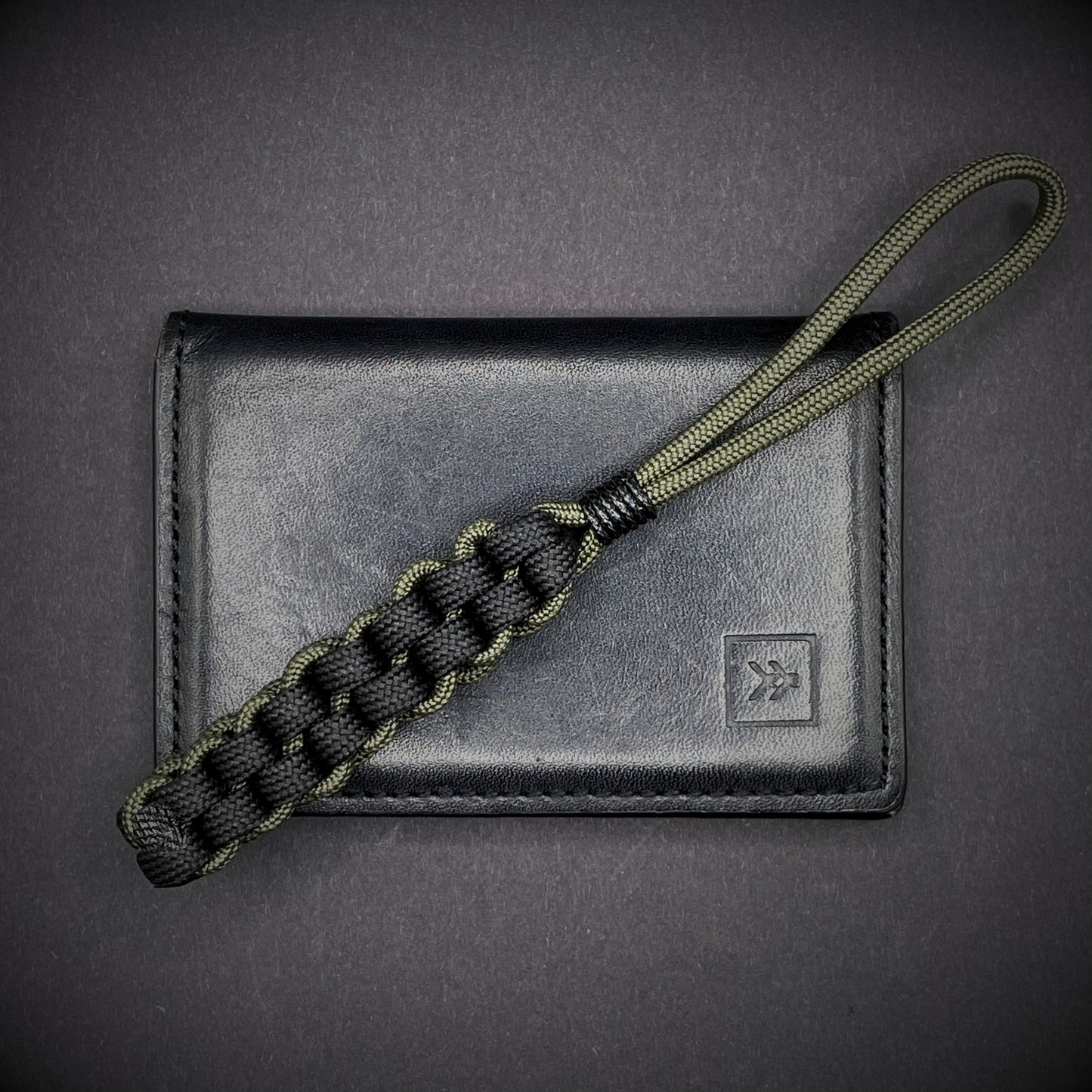 Flat lay of a 3 550 Paracord knife lanyards on a dark grey background