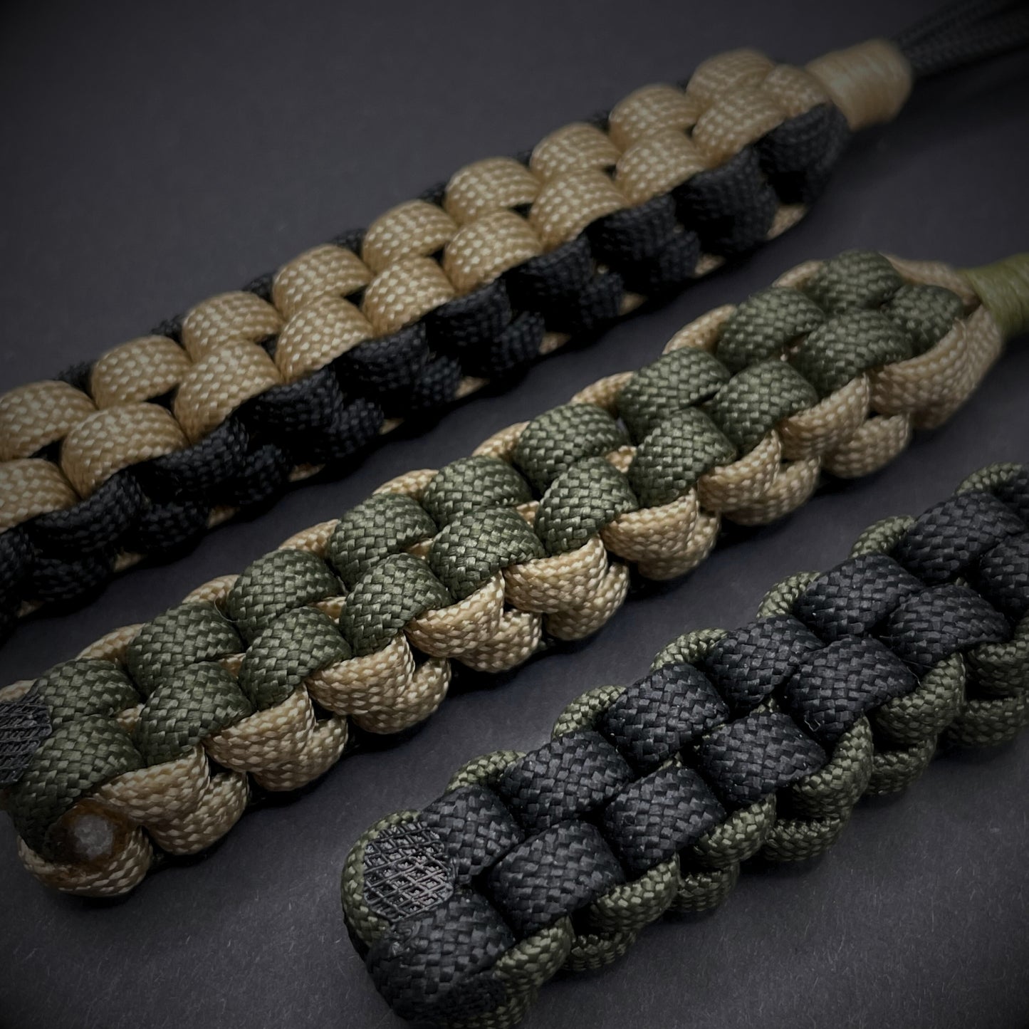 Flat lay of a 3 550 Paracord knife lanyards on a dark grey background