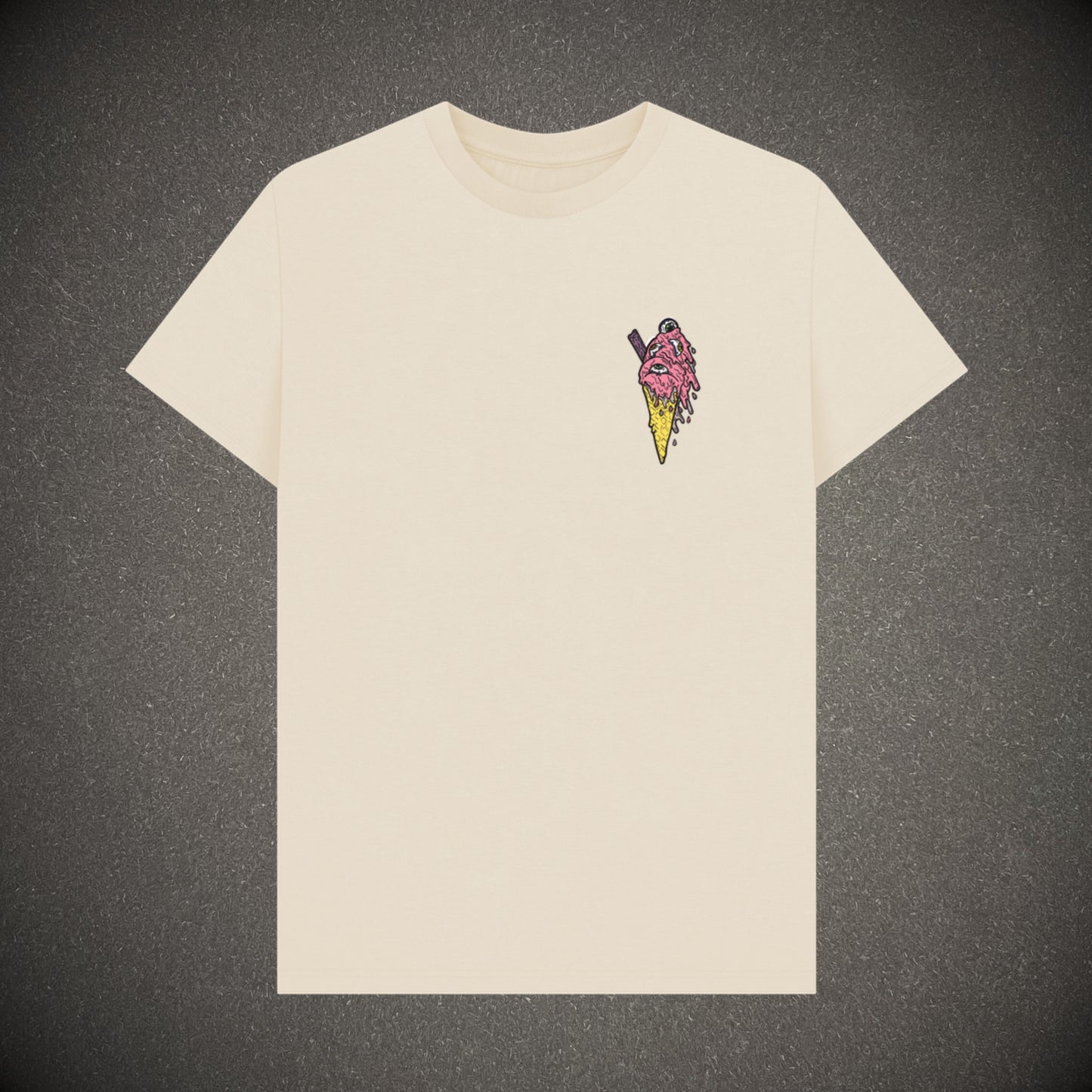 Oat coloured t-shirt on a dark grey background, the t-shirt has an ice cream with eyes in as a logo print.