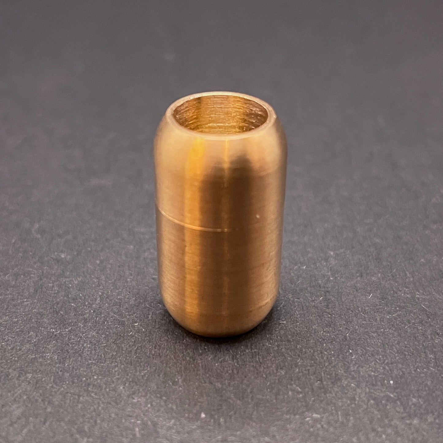 Rose Gold cylindrical metal magnetic bracelet clasp, displayed on a dark textured background.