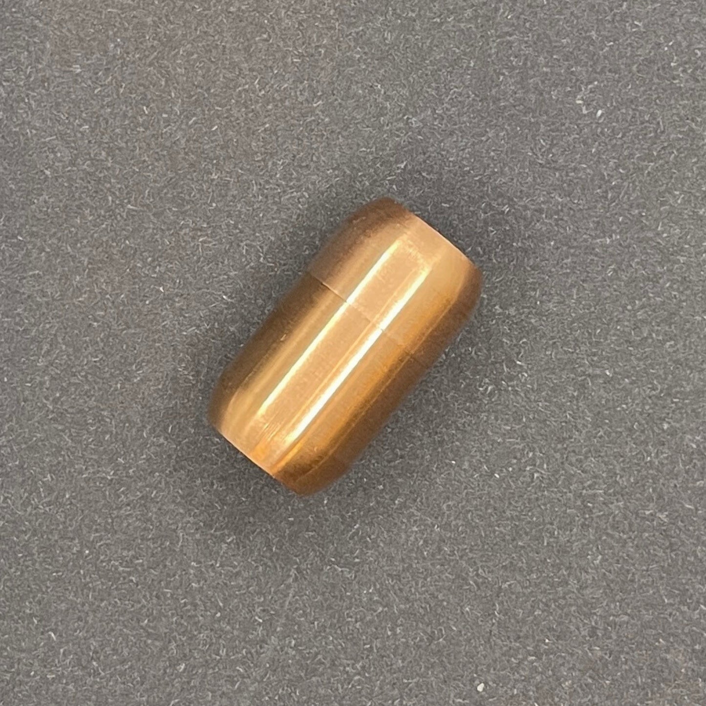Rose Gold cylindrical metal magnetic bracelet clasp, displayed on a dark textured background.