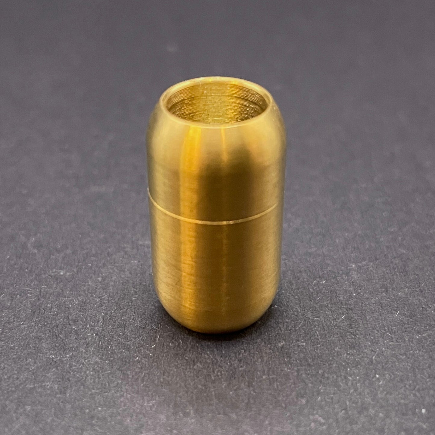 Brushed Gold cylindrical metal magnetic bracelet clasp, displayed on a dark textured background.