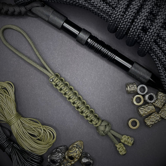 Flat lay of a army green 550 Paracord knife lanyards on a dark grey background