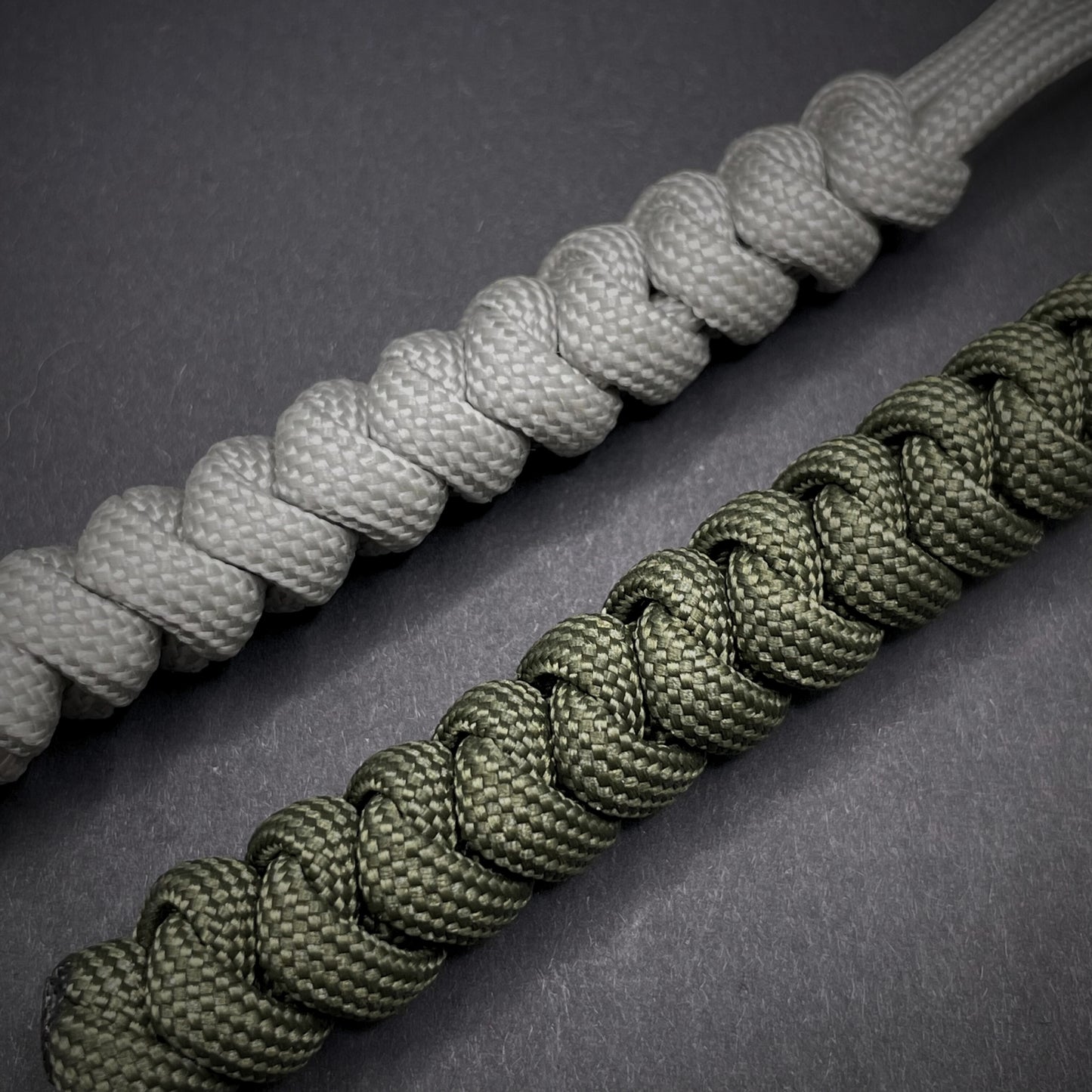 Flat lay of a 2 550 Paracord knife lanyards on a dark grey background