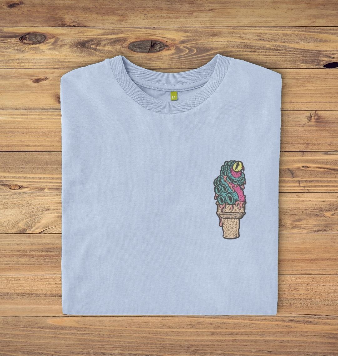 Folded Sky blue t-shirt on a oak panelled background, the t-shirt has an ice cream octopus logo print.