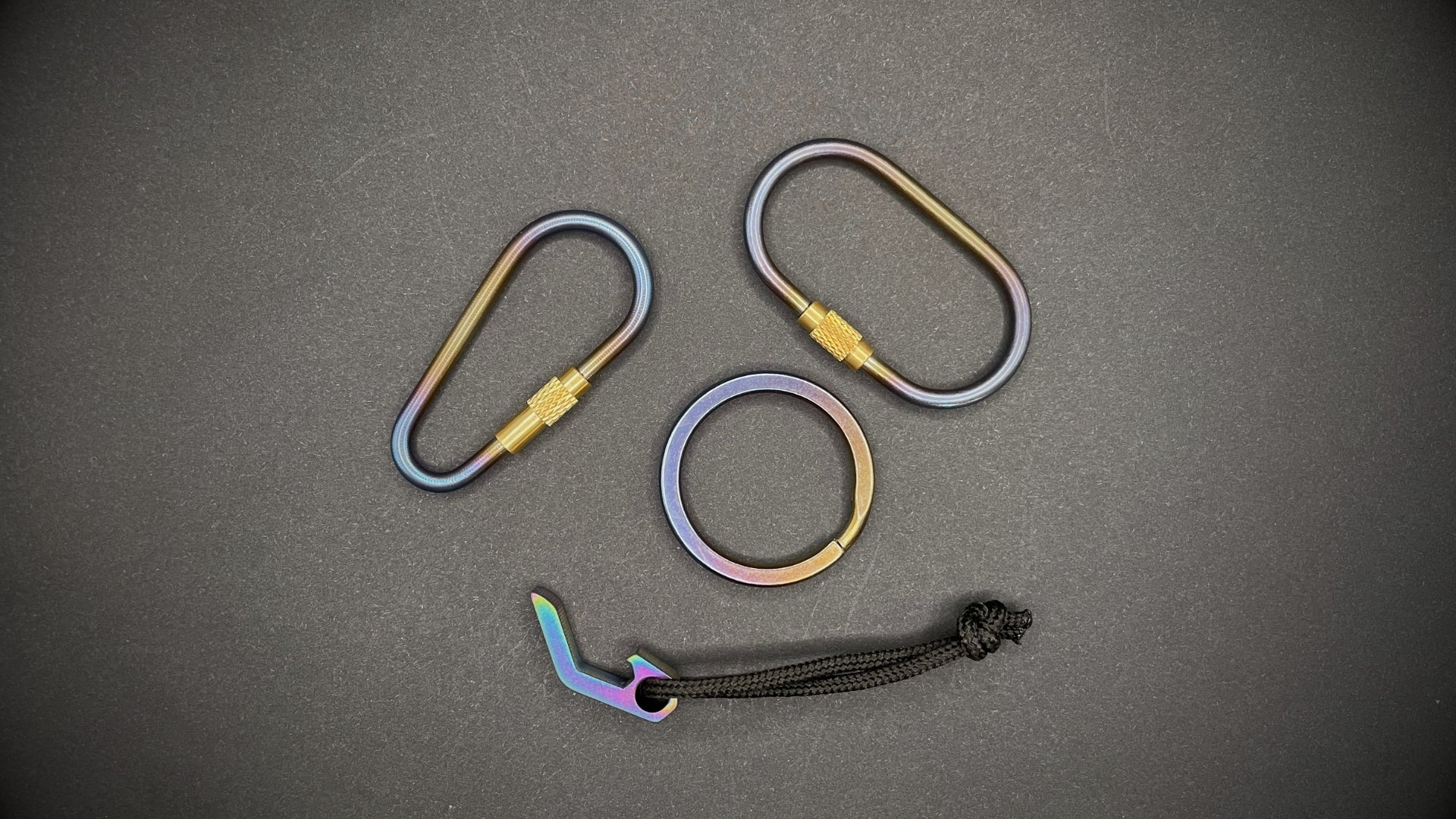 A selection of Titanium EDC items arranged on a dark grey surface.