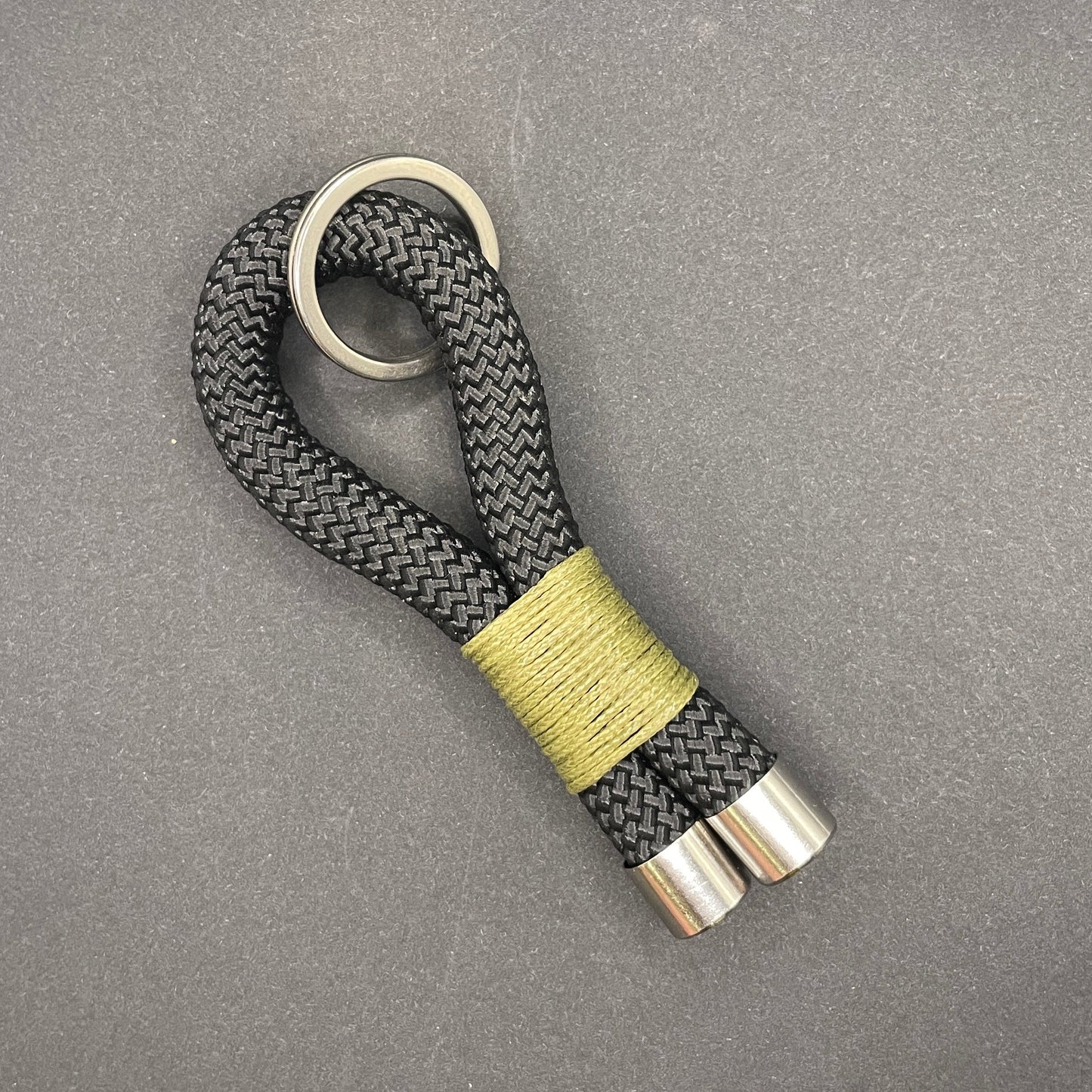 Keychain with braided design and metallic accents on a gray background