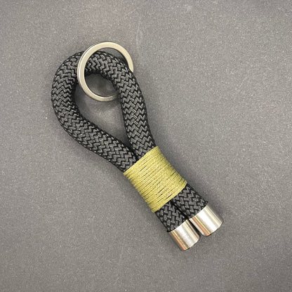Keychain with braided design and metallic accents on a gray background