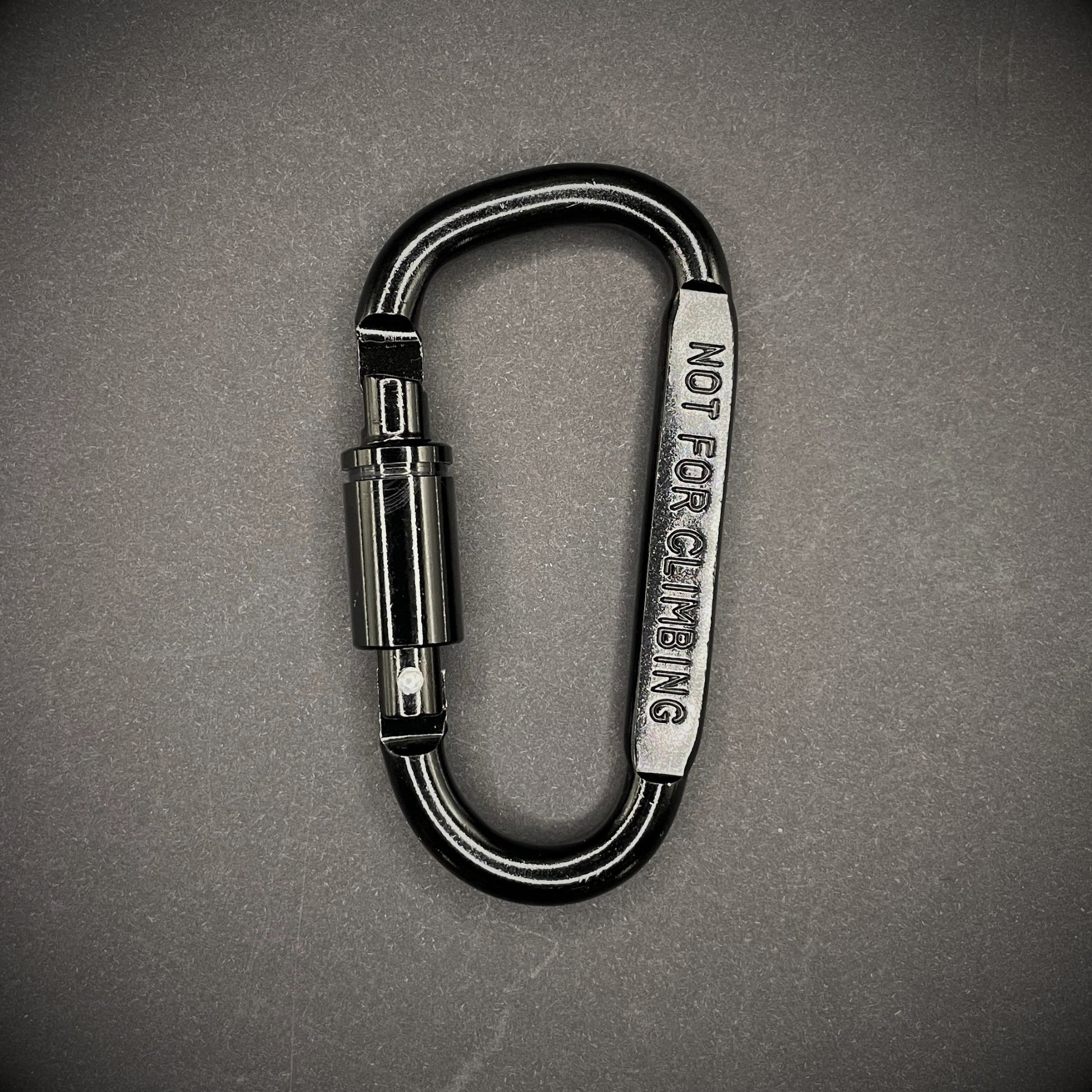 Black carabiner marked 'NOT FOR CLIMBING' on a dark grey background.