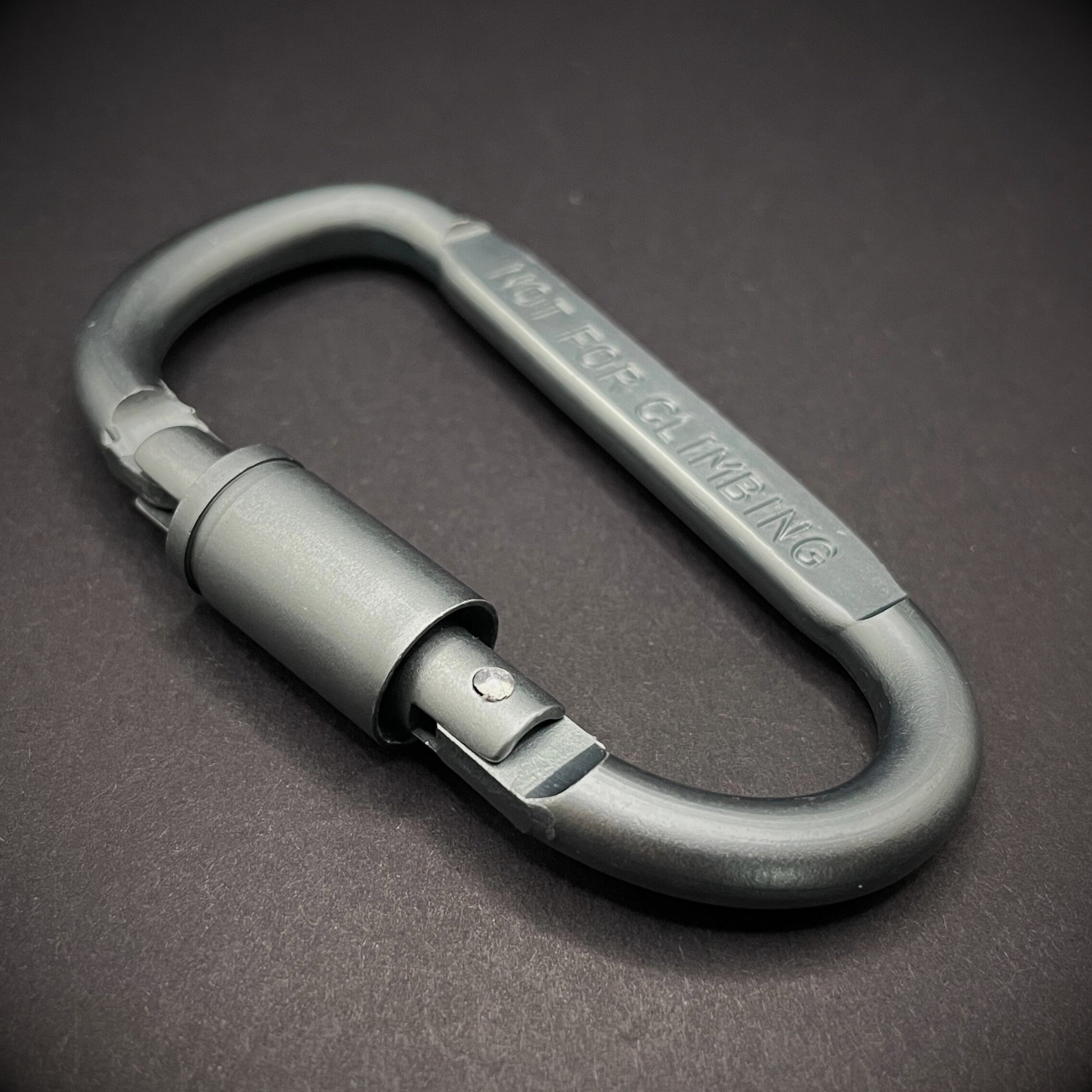Grey carabiner marked 'NOT FOR CLIMBING' on a dark grey background.