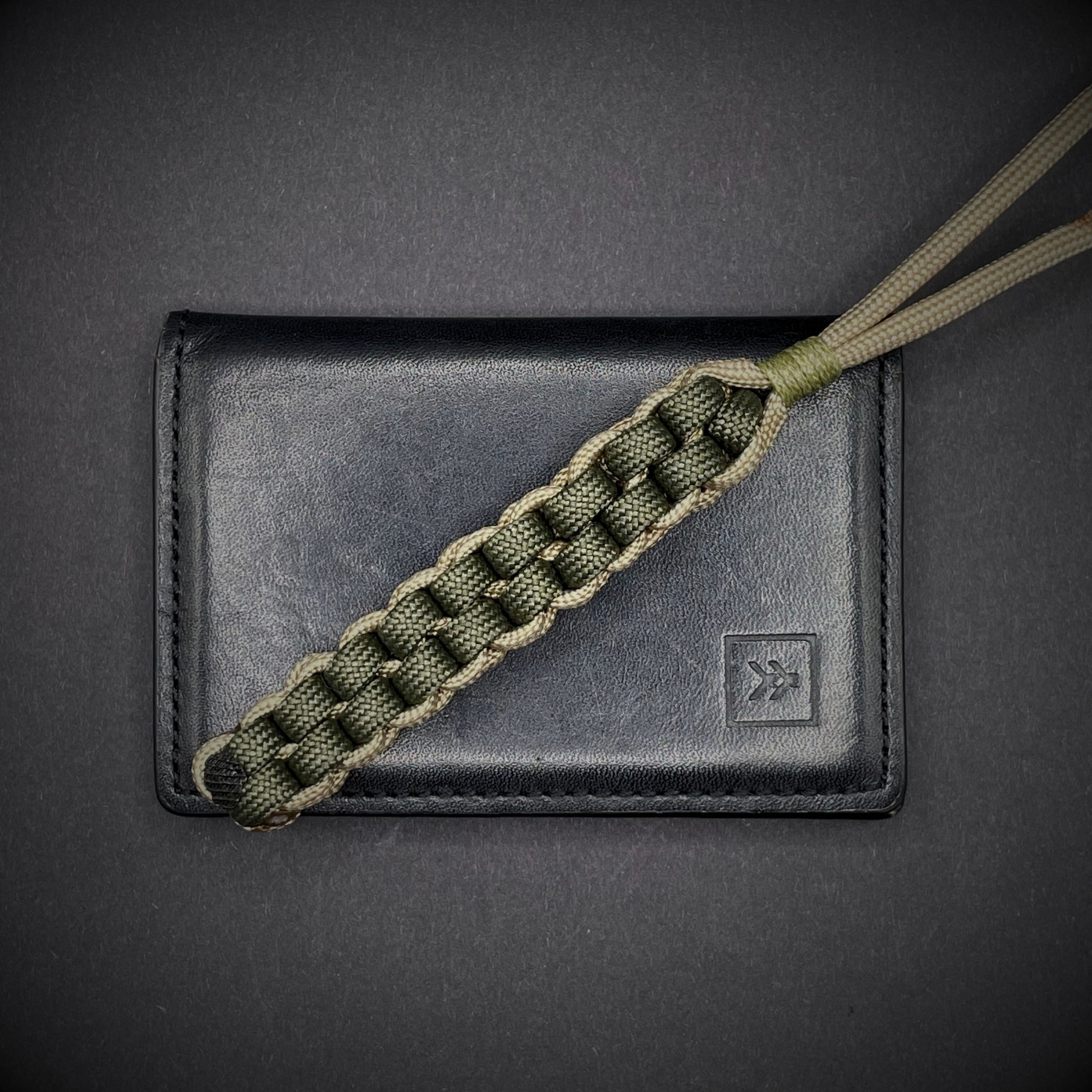 Flat lay of a 3 550 Paracord knife lanyards on a dark grey background