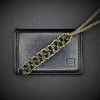 Flat lay of a 3 550 Paracord knife lanyards on a dark grey background