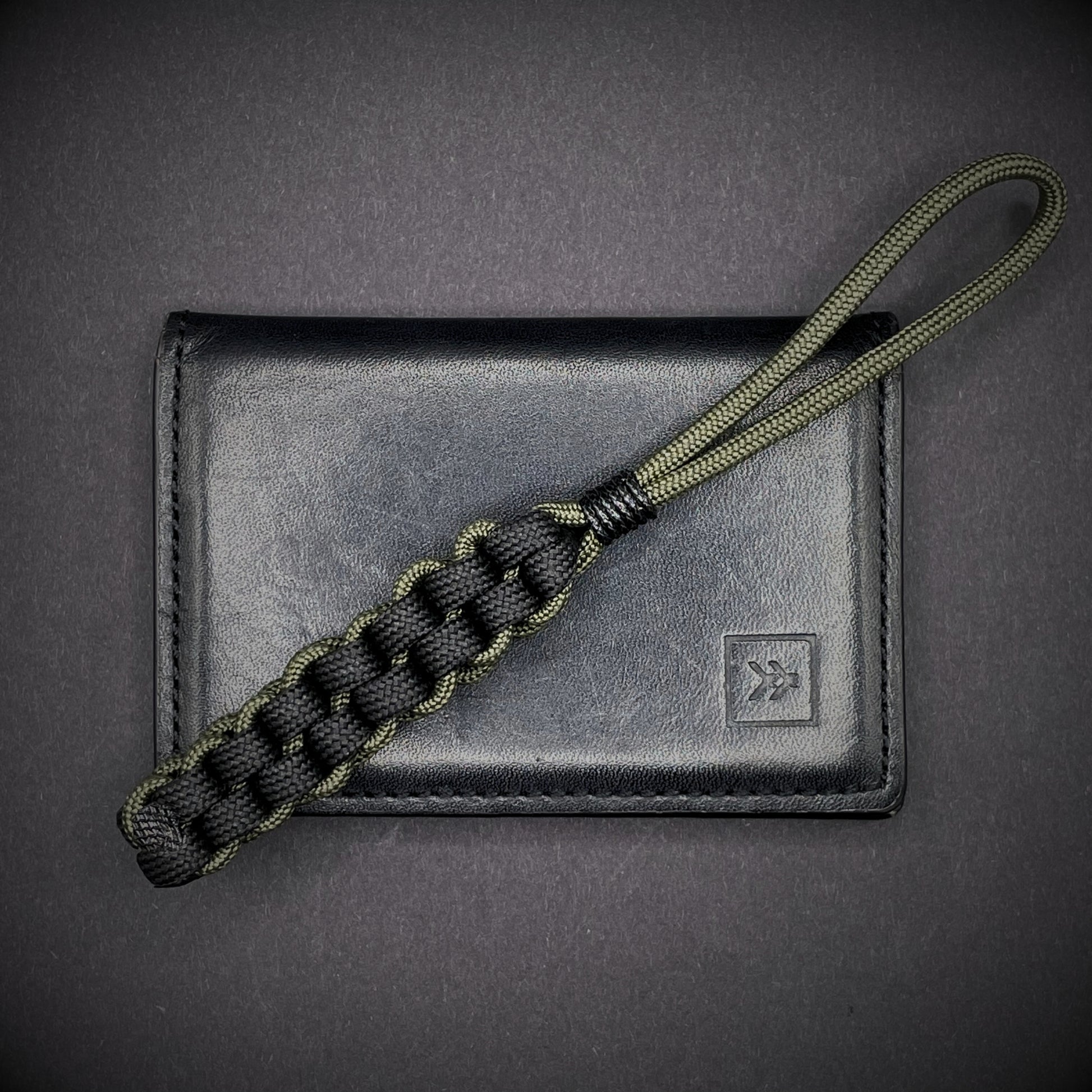 Flat lay of a 3 550 Paracord knife lanyards on a dark grey background