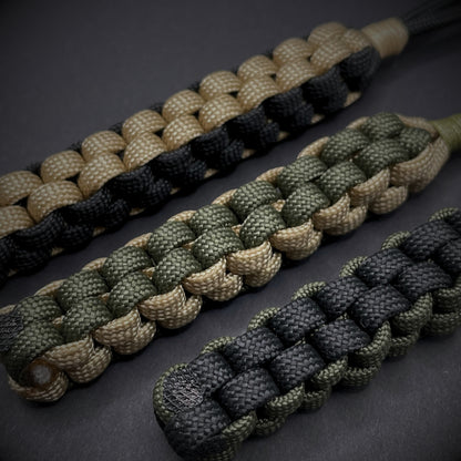 Flat lay of a 3 550 Paracord knife lanyards on a dark grey background