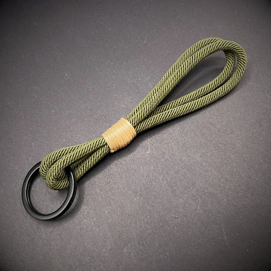 Flat lay of Green Milan Rope keychain with tan cotton whipping on a dark background.