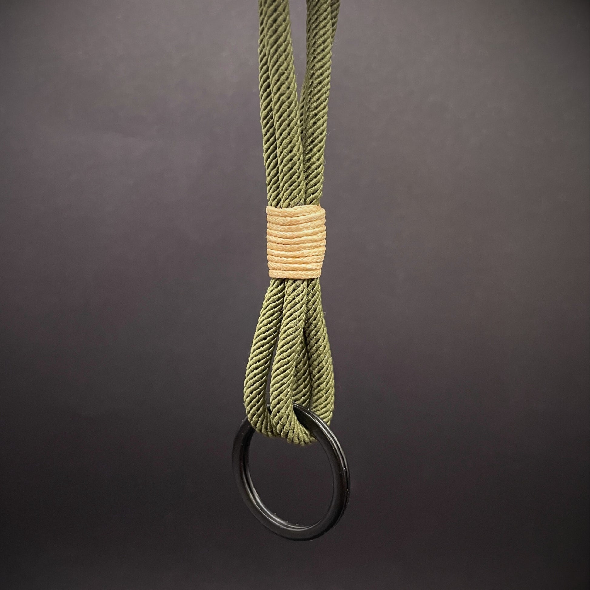 Flat lay of Green Milan Rope keychain with tan cotton whipping on a dark background.