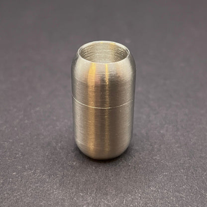 Stainless Steel cylindrical metal magnetic bracelet clasp, displayed on a dark textured background.