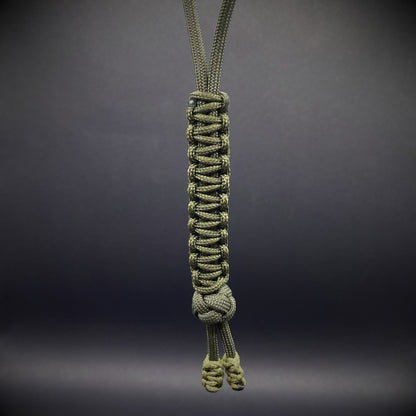 Flat lay of a army green 550 Paracord knife lanyards on a dark grey background