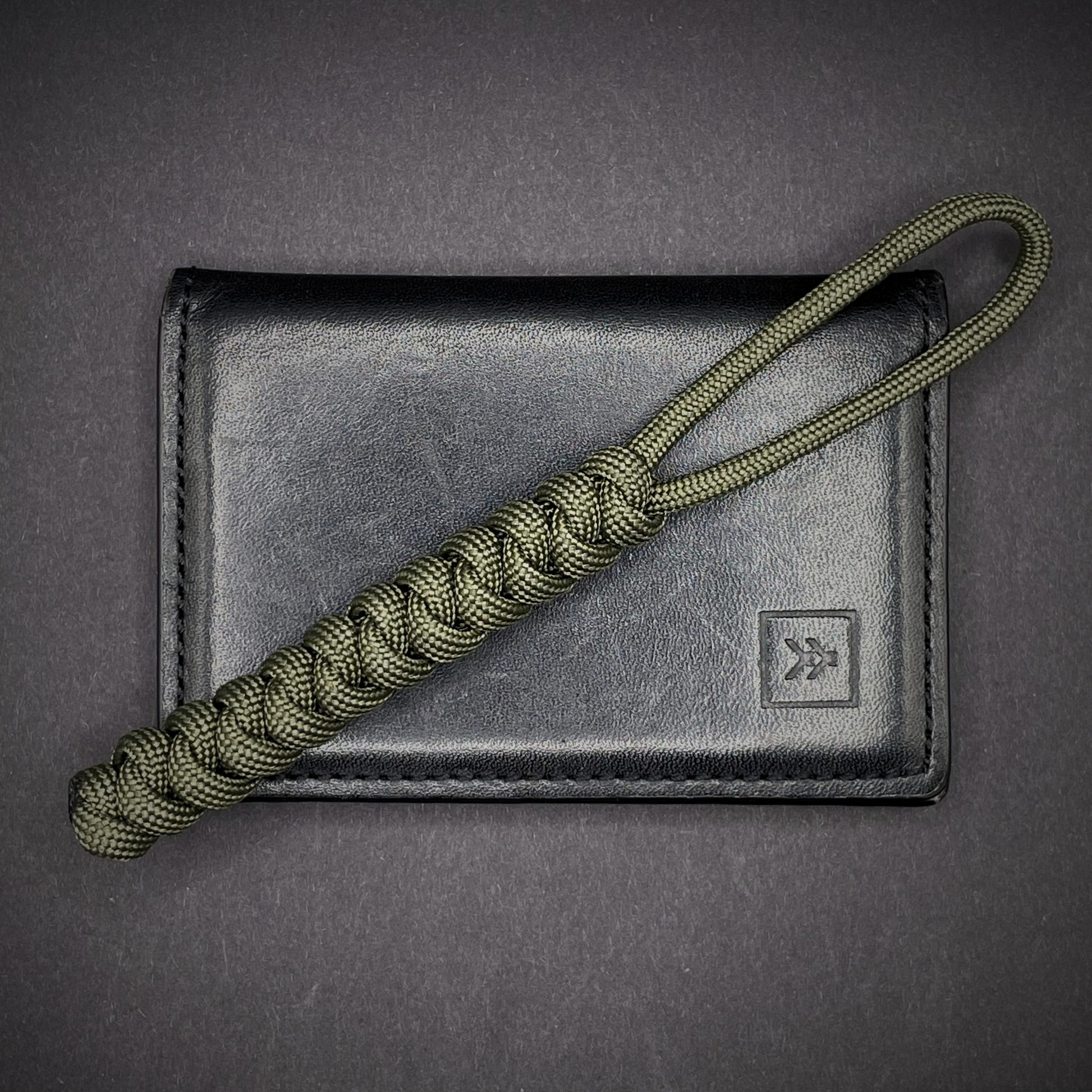 Flat lay of a 3 550 Paracord knife lanyards on a dark grey background