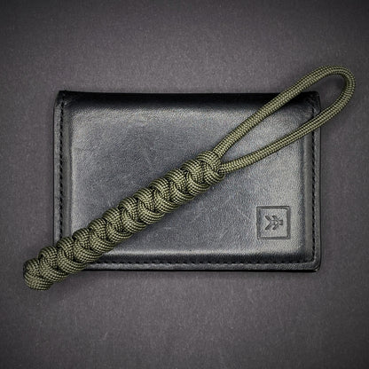 Flat lay of a 3 550 Paracord knife lanyards on a dark grey background