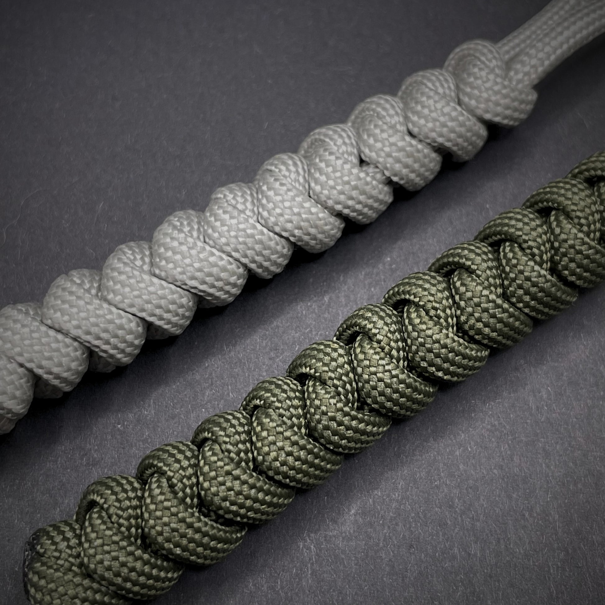 Flat lay of a 2 550 Paracord knife lanyards on a dark grey background
