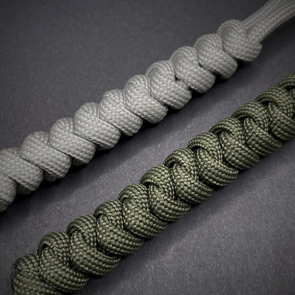 Flat lay of a 2 550 Paracord knife lanyards on a dark grey background