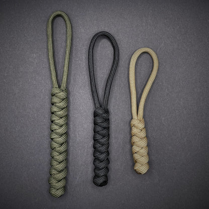 Flat lay of a 3 550 Paracord knife lanyards on a dark grey background